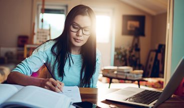 person studying at home with laptop