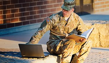 student wearing fatigues on laptop